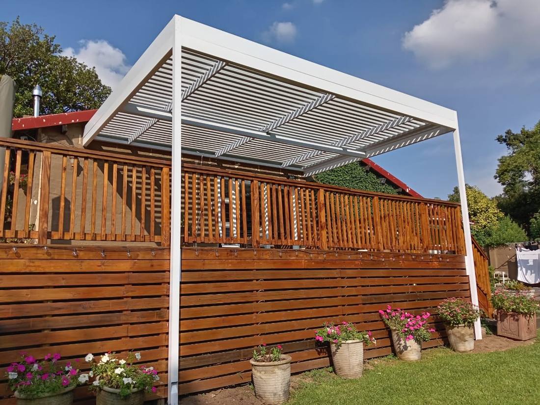 White adjustable louvre over a raised timber deck in Morningside, blades open