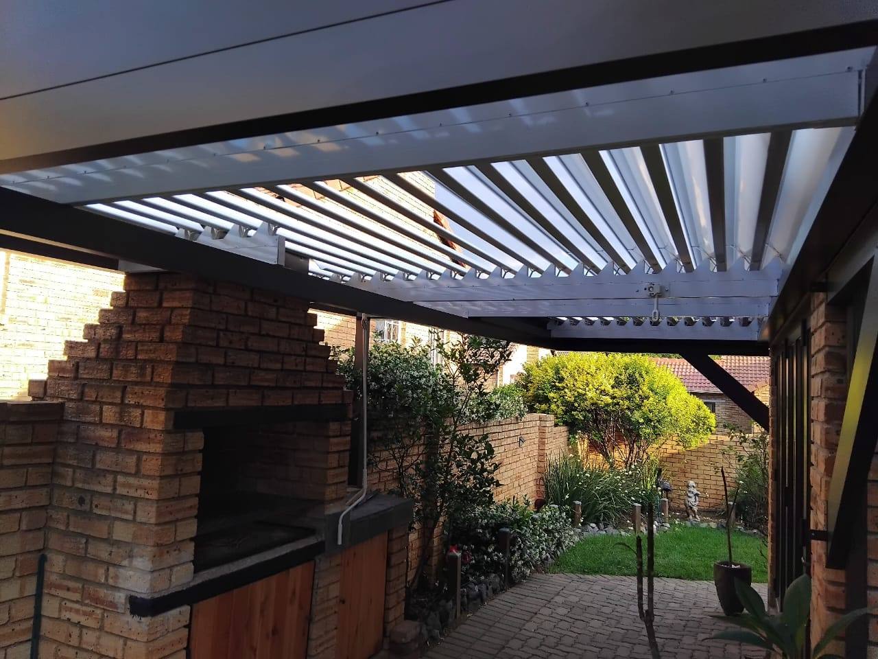 Bronze louvre roof over a built-in braai in Wilgeheuwel, blades open